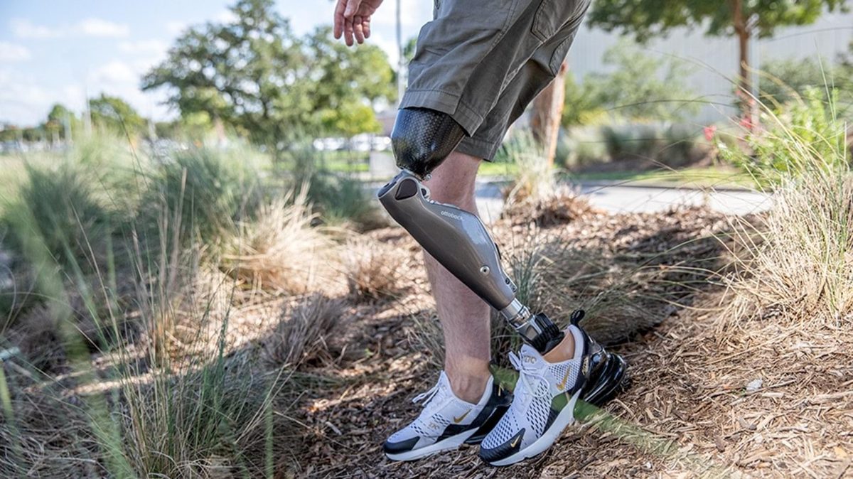 Person walking outdoors with a below-knee prosthesis